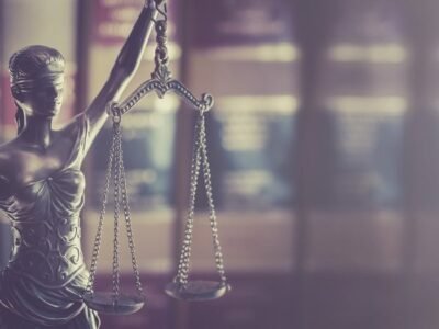 Άγαλμα της Θέμιδας μπροστά σε νομικά βιβλία, για την ευθύνη της δικαστικής λειτουργίας